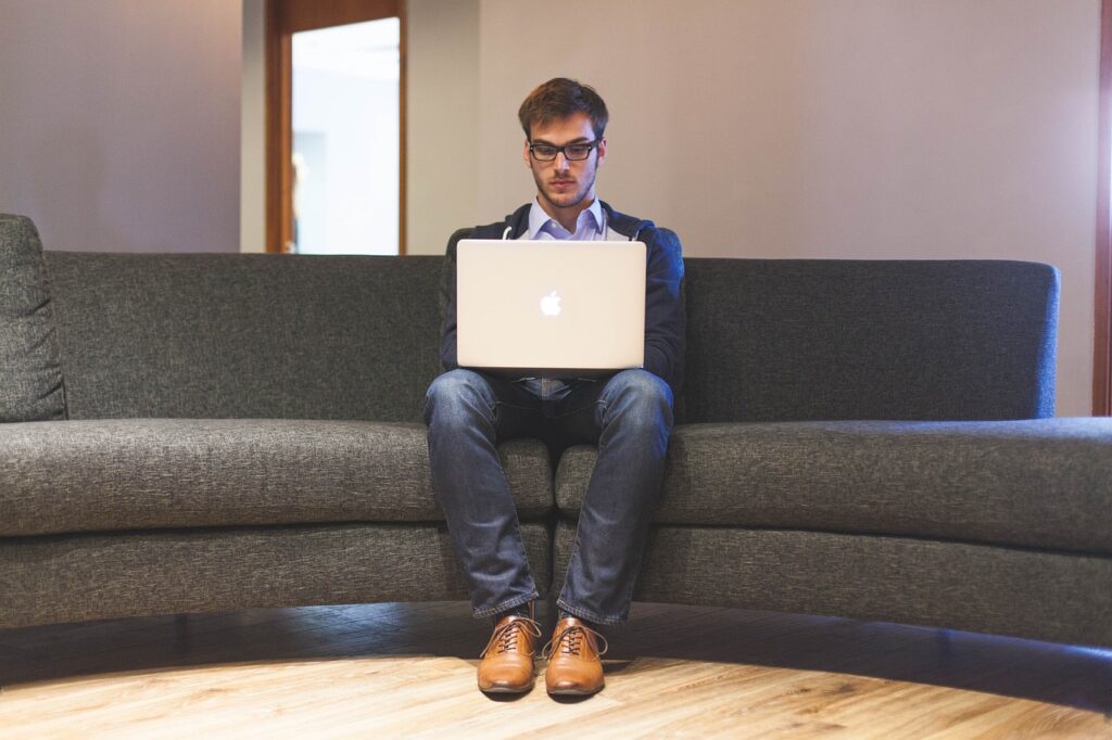 Unternehmer arbeitet am Laptop auf der Couch SEO für Handwerker Tipps und Tricks 2023