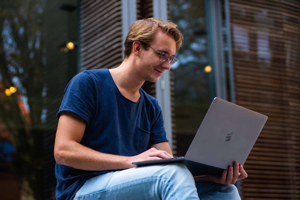 junger Mann blickt interessiert auf sein Laptop Werbung neu entdecken Die Veränderungen des 21. Jahrhunderts